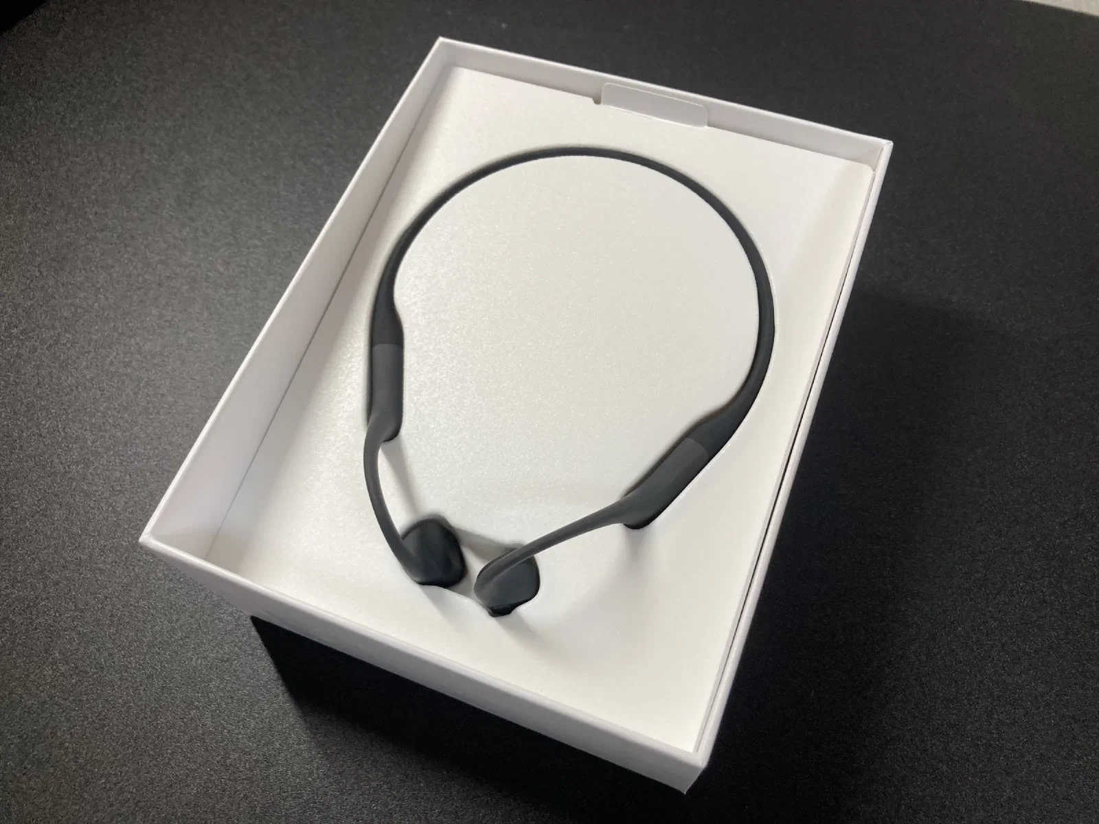 箱を開けたところ。黒いネックバンド型の本体が白いトレイに収まっている