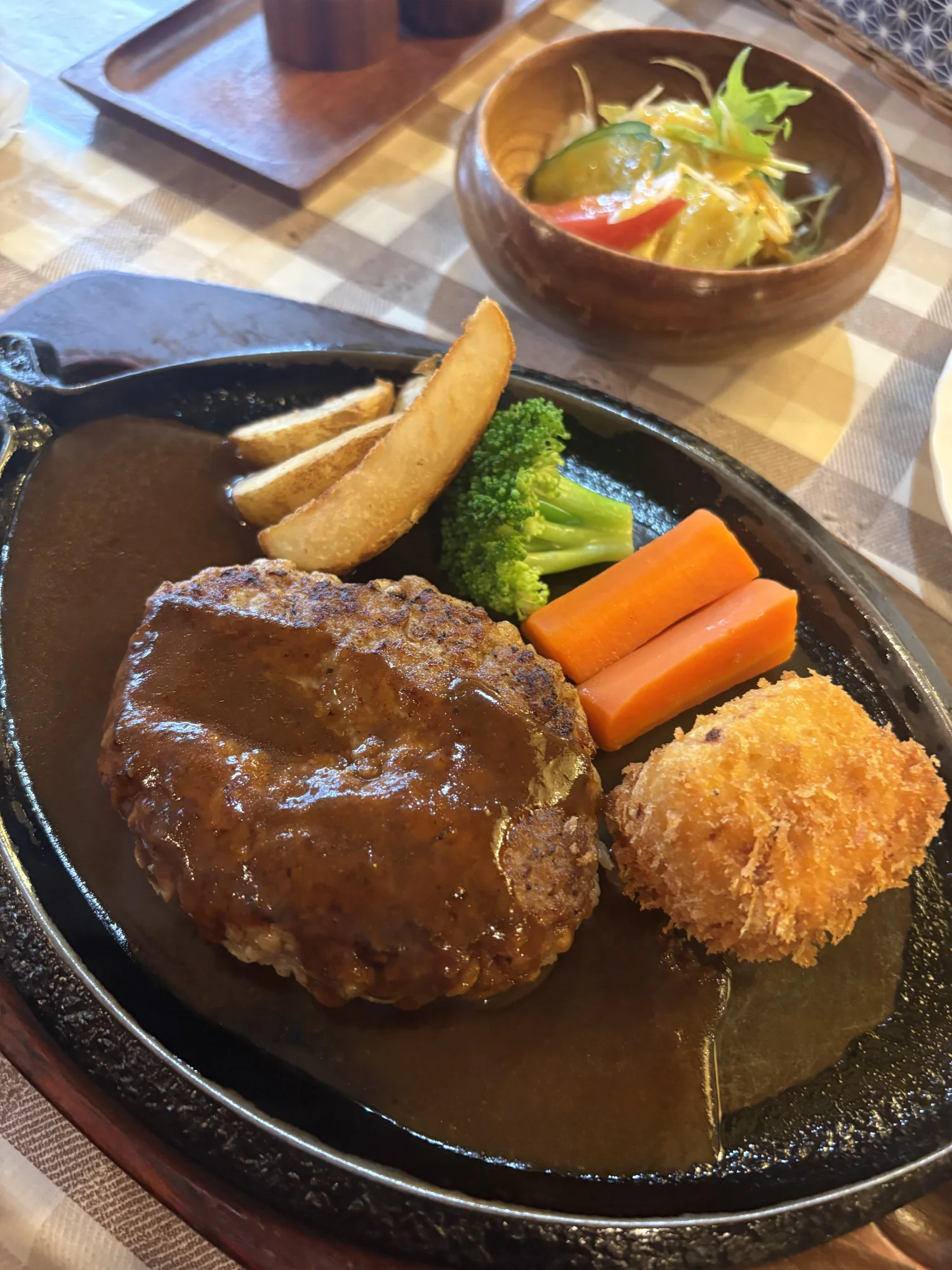 鉄板にのったハンバーグとカニクリームコロッケ、ブロッコリーとにんじん、ポテト